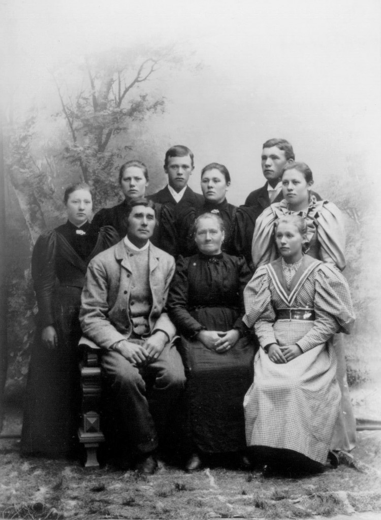 Detta kort på familjen är förmodligen taget omkring 1895. Barnen från vänster: Gertrud Lisa, Brita Carolina, Nils Erik, Märta Kristina, Johan Olof, Anna Lena och Margareta Augusta (identifierade av Märta Jönsson 1980).